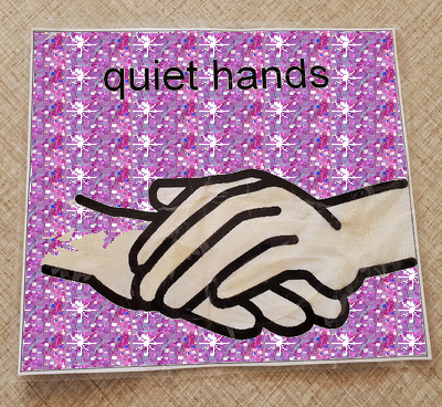 a piece of paper that reads 'quiet hands' with accompanying image of two still, resting hands